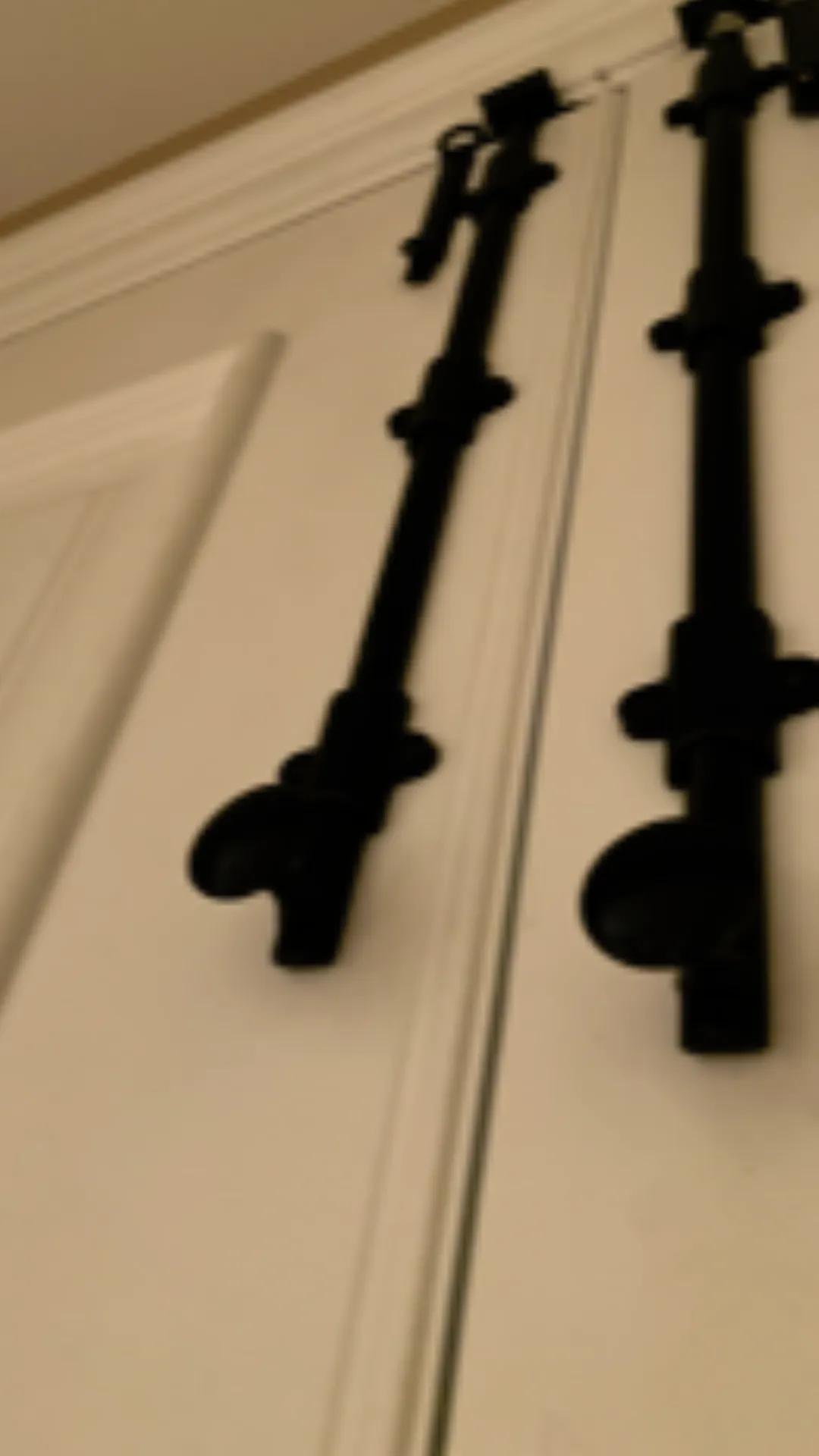 Blurry black door handles on white doors.