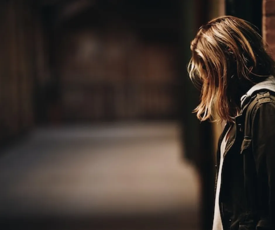 Person standing in dimly lit corridor.