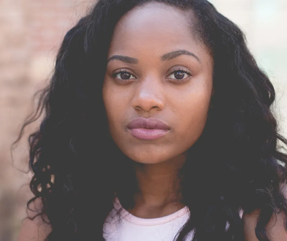 Woman with long hair, neutral expression.