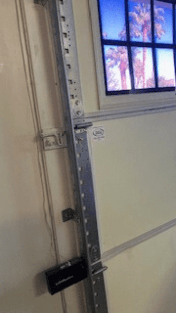 Garage door with metal rail and window.